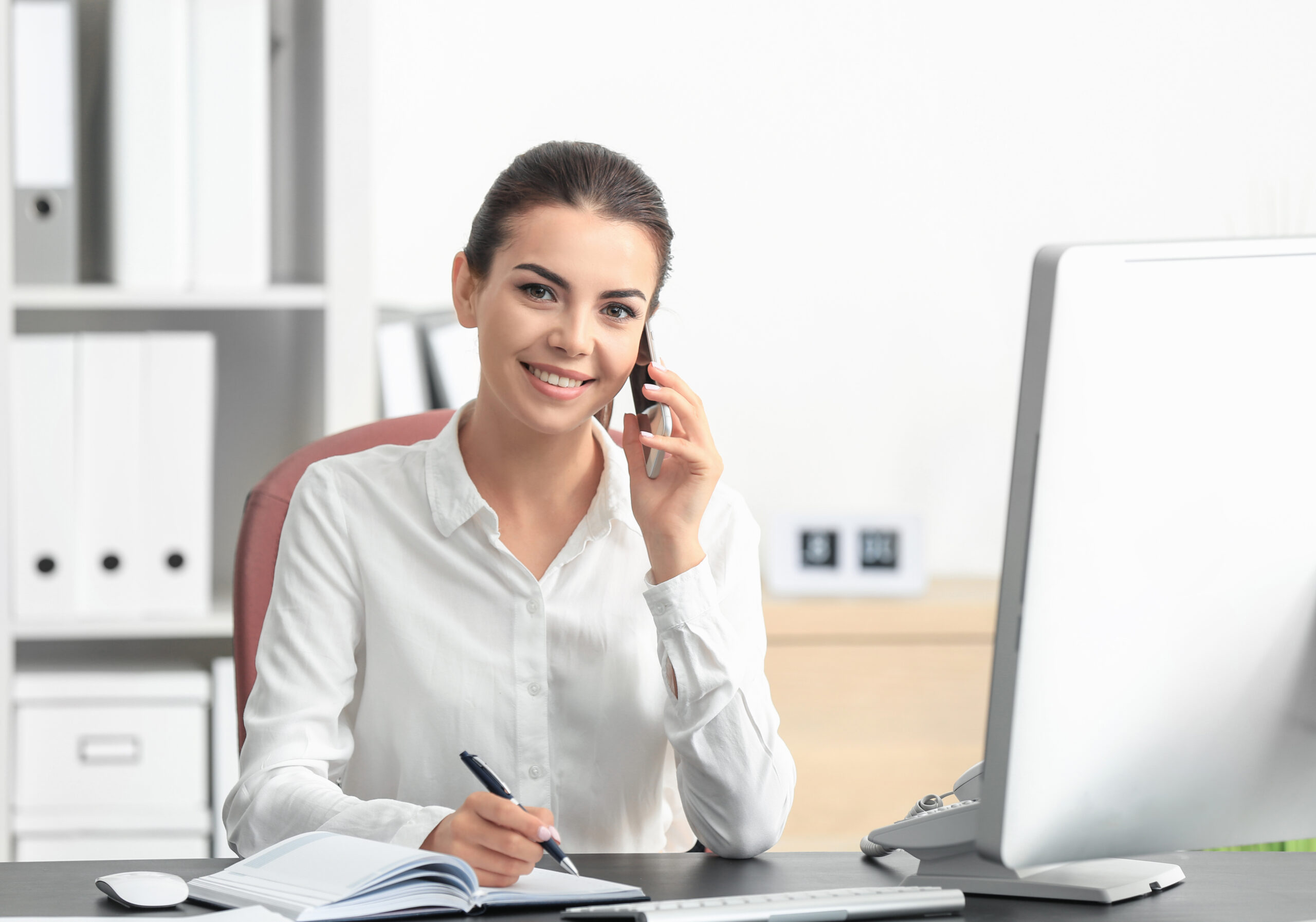 Young,Female,Receptionist,Talking,On,Phone,In,Office